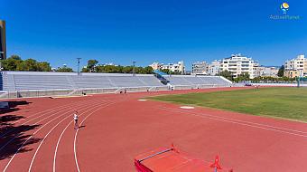 Leichtathletikbahn mit roten Bahnen und leeren Tribünen, vorbereitet für Trainingseinheiten