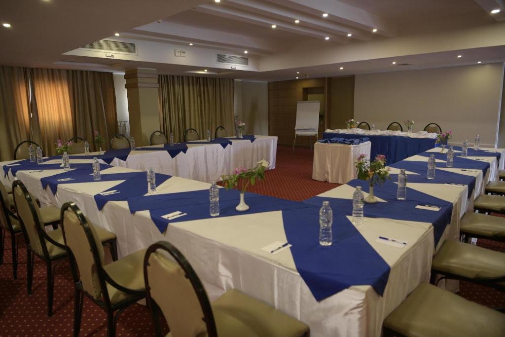 Salle de conférence avec tables en U, bouteilles d'eau et tableau à feuilles mobiles.