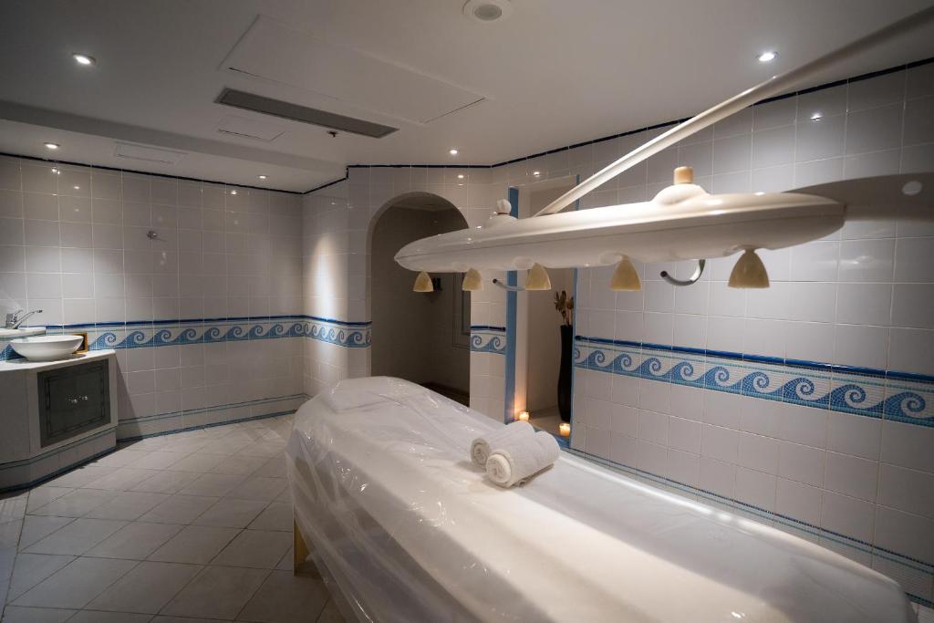 Salle de soins spa avec table de massage et lampe chauffante pour récupération d'athlètes en stage d'entraînement