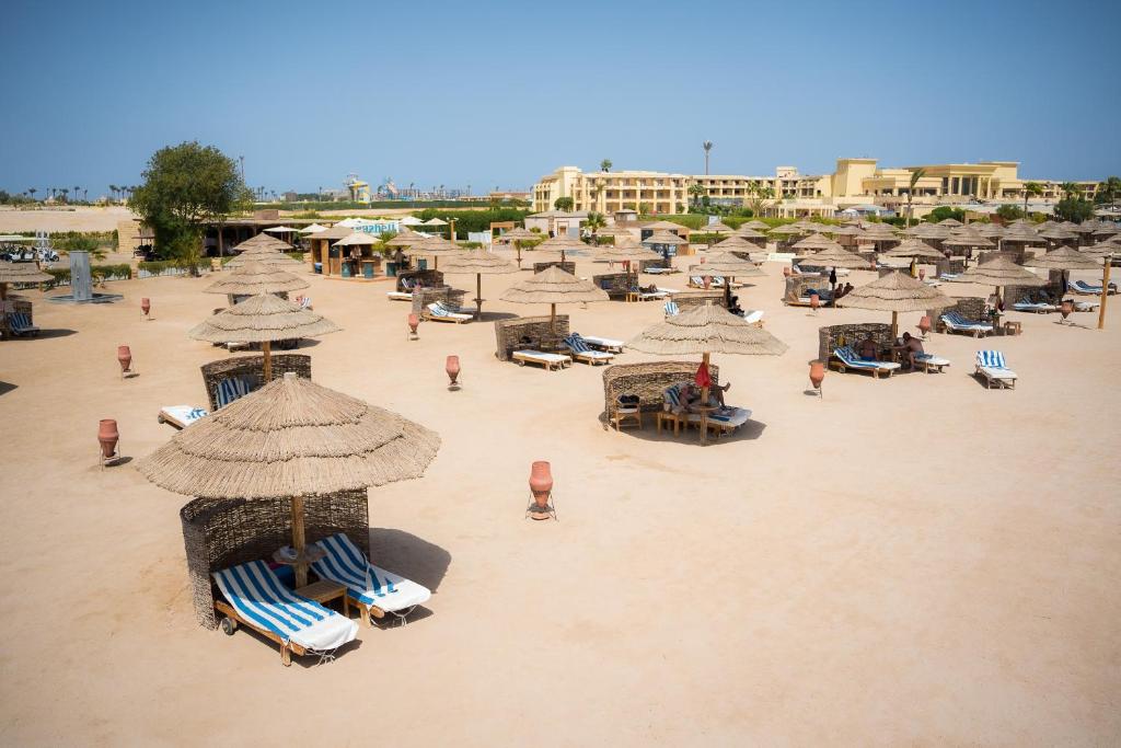 Large plage de sable avec transats et parasols en paille, parfaite pour jours de repos au bord de la mer