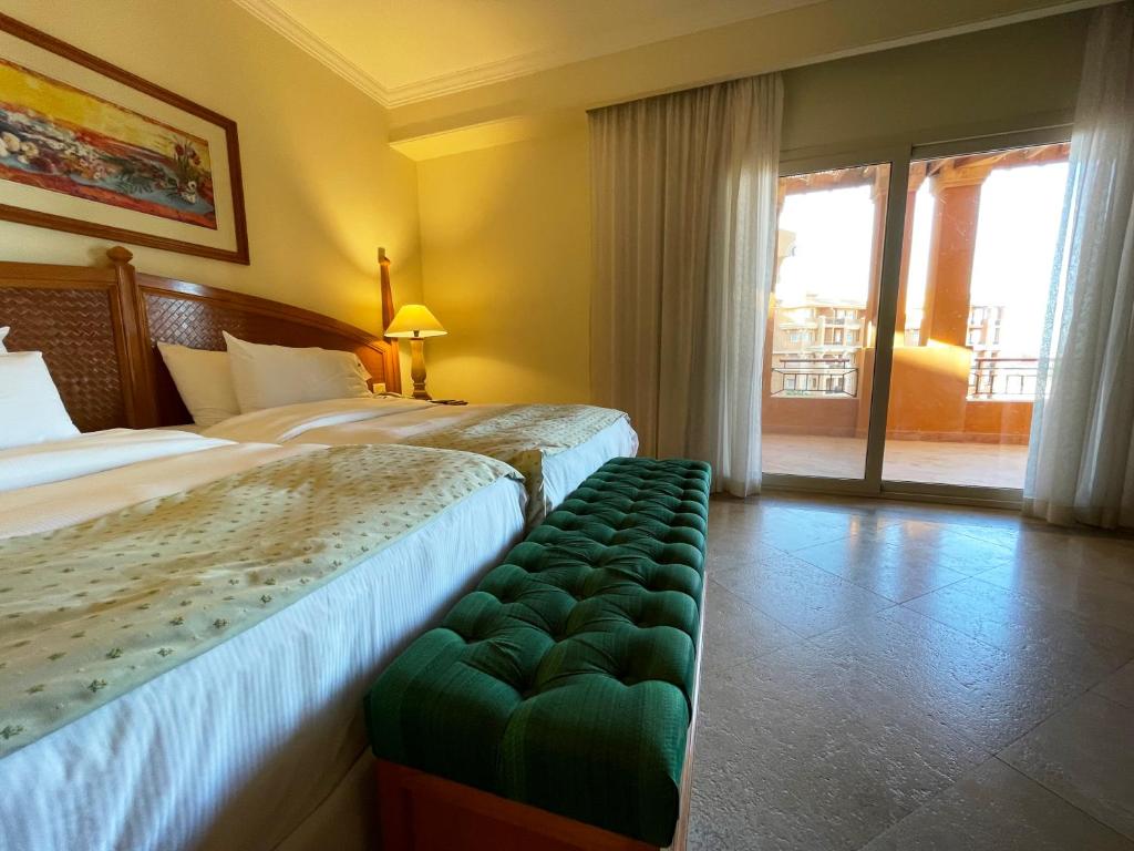Chambre avec lits jumeaux et accès au balcon pour hébergement d'équipe confortable.