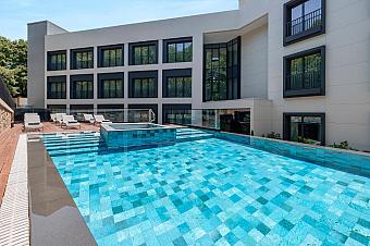 Außenpool im Hotelhof mit Sonnenliegen und Terrassenbestuhlung.