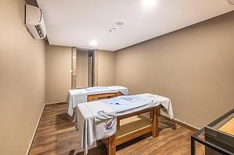 Massage and treatment room with two therapy tables and towels for recovery sessions.