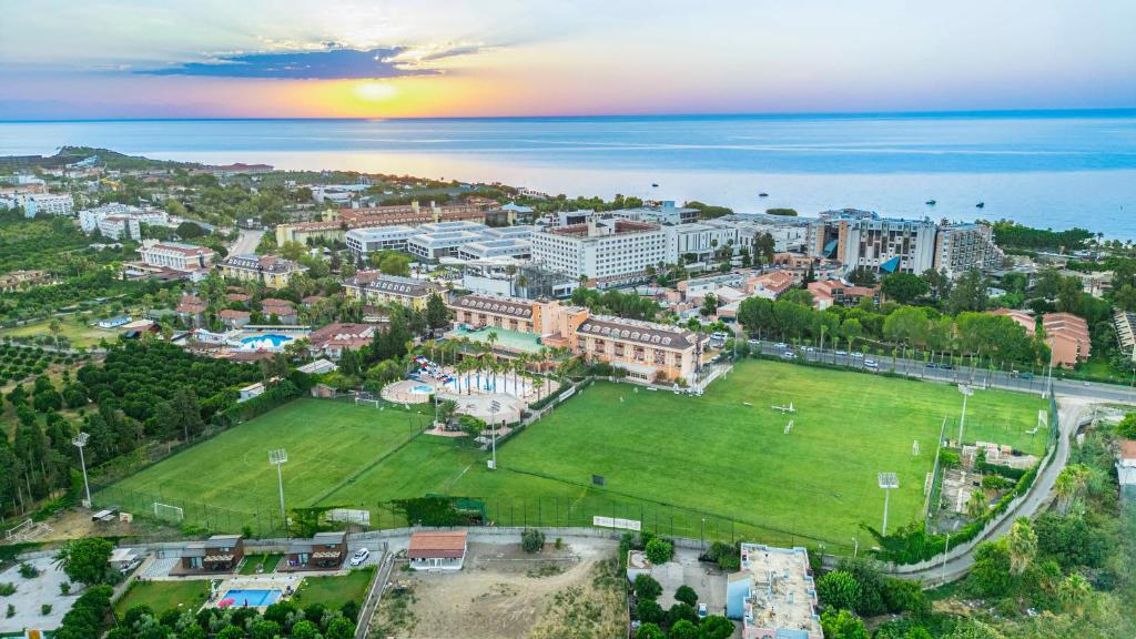 Vue aérienne au coucher du soleil du complexe et d'un terrain de football surplombant la mer.