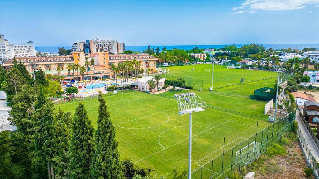 Vue aérienne de la zone du complexe avec deux terrains de football et bâtiments environnants près de la côte.