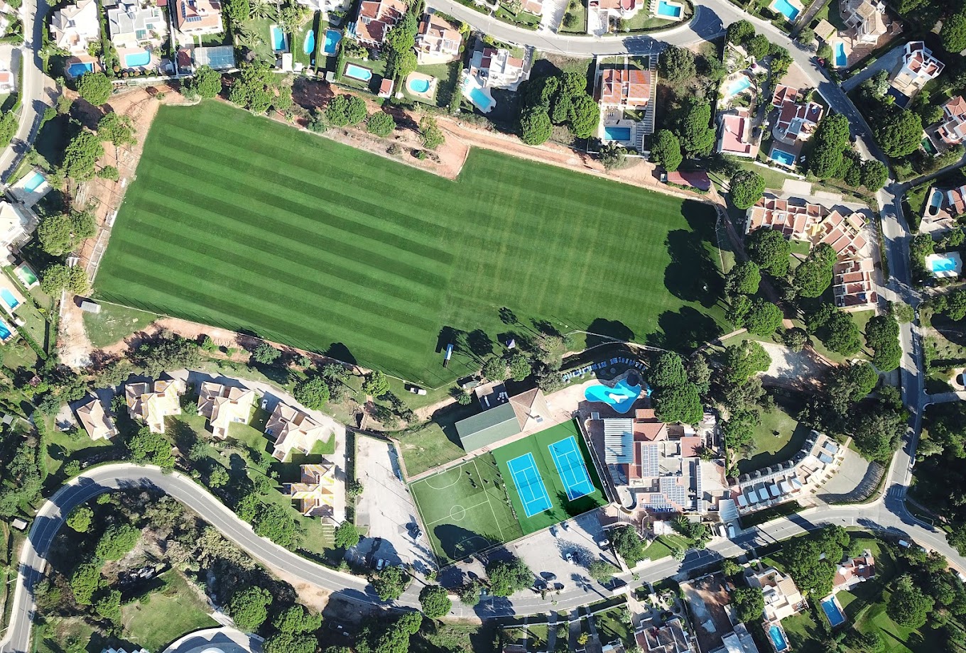 Vue aérienne du complexe avec terrain de football pleine grandeur et terrains adjacents.
