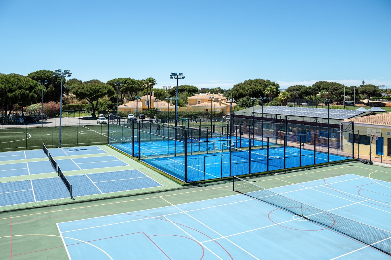 Vue d'ensemble des installations de tennis, padel et football pour un stage sportif.