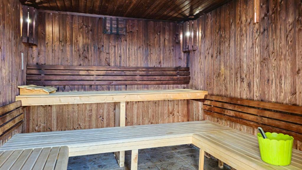Sauna en bois avec bancs étagés et seau.