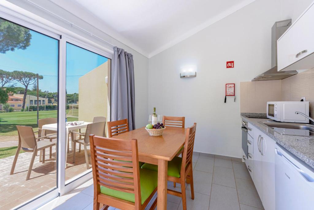 Kitchenette et coin repas avec portes coulissantes vers une terrasse.
