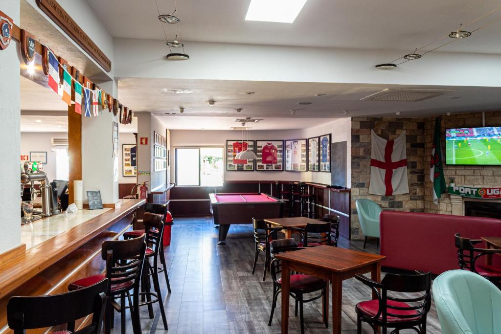 Bar sportif lounge avec table de billard, assises et écrans TV.
