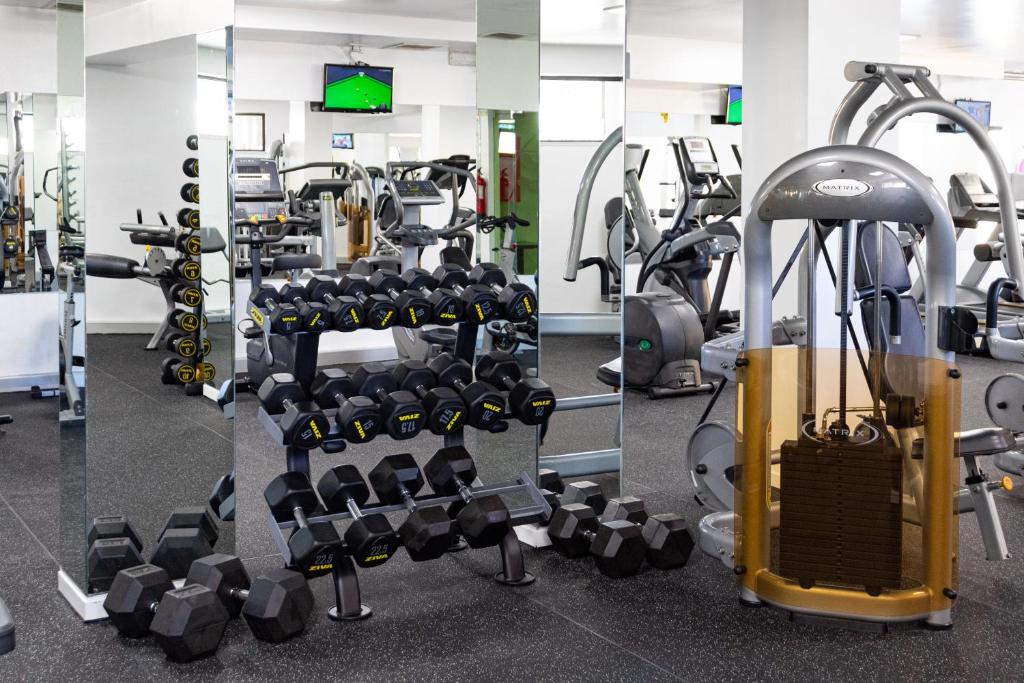 Espace musculation avec poids libres, rack d'haltères et machine de renforcement.