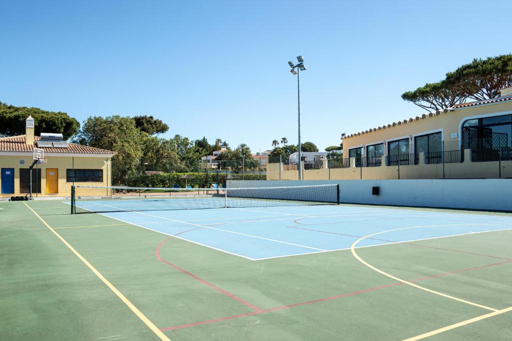 Terrain multisport extérieur en surface dure avec filet et panier de basket.