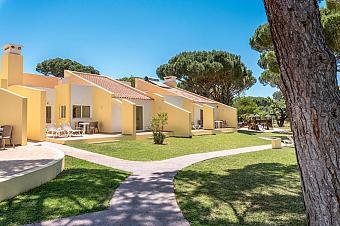 Außenansicht der Bungalow-Unterkünfte mit privaten Terrassen, Rasenflächen und Gehwegen.