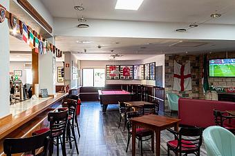 Sportbar-Lounge mit Billardtisch, Sitzplätzen und TV-Bildschirmen.