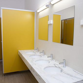 Modernes Gemeinschaftsbad mit vier Waschbecken, Spiegeln und gelben Trennwänden.