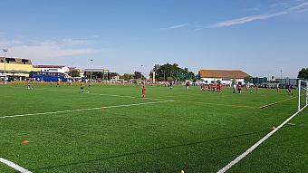 Jugendspieler absolvieren Fußballübungen auf einem Kunstrasen-Trainingsplatz.