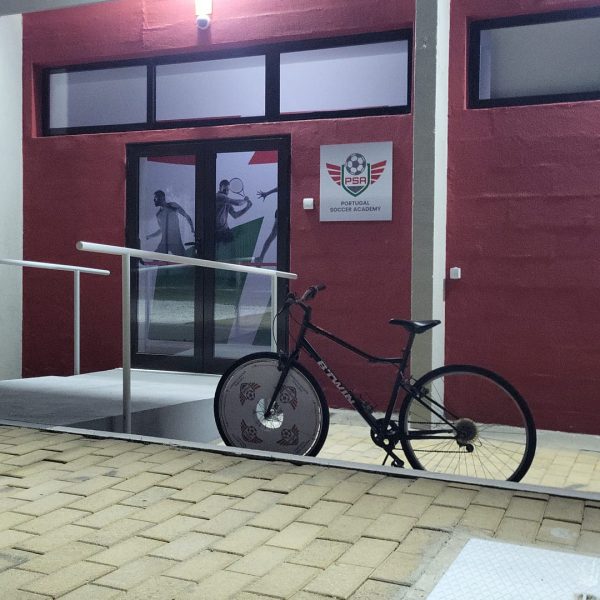 Entrée du bâtiment de la Portugal Soccer Academy avec un vélo garé à l'extérieur.
