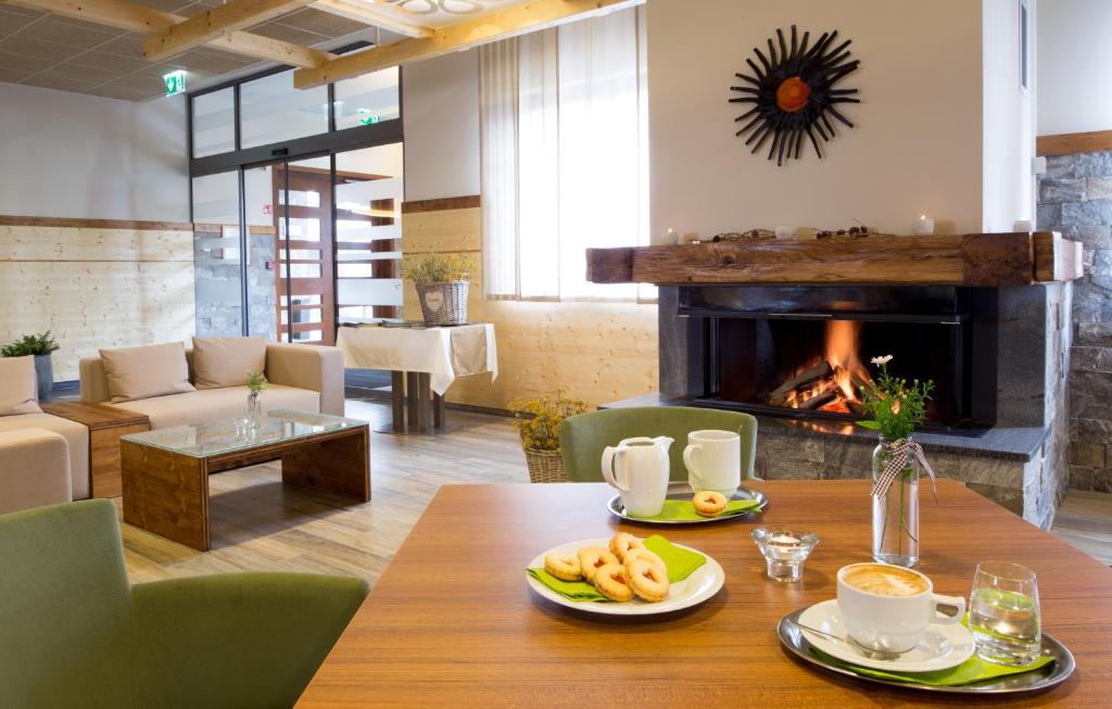 Lounge area with fireplace, sofas and coffee service on a table.