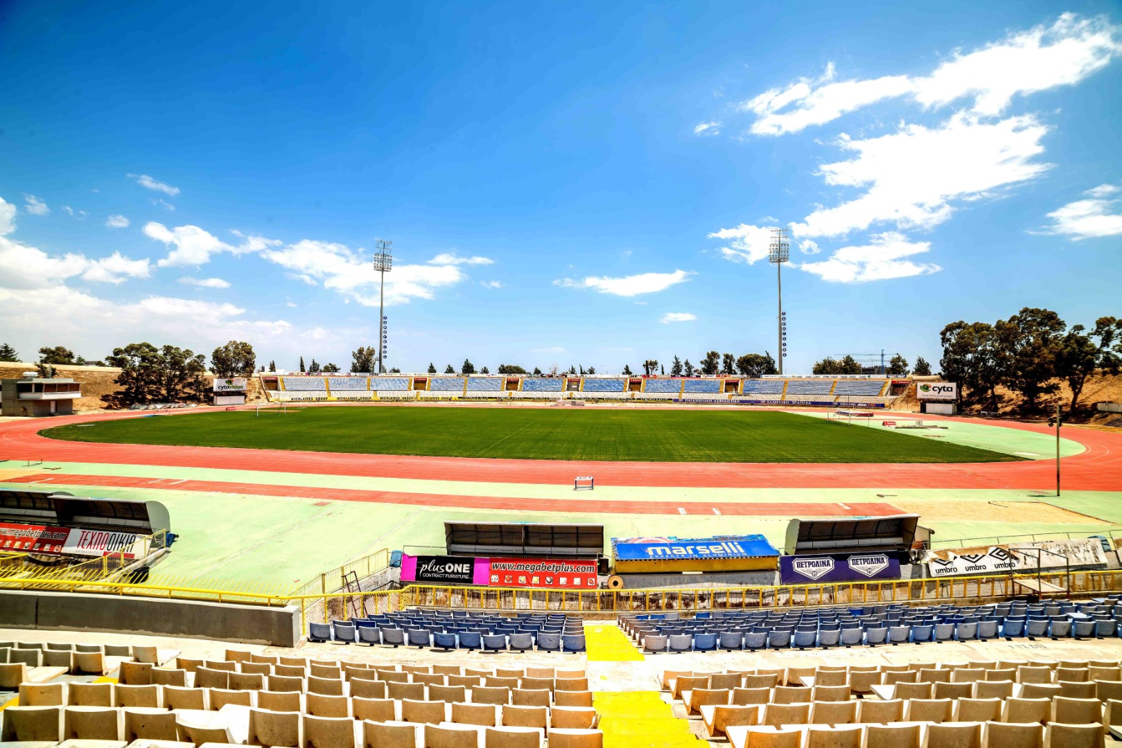 Außenstadion mit Rasenfeld, Laufbahn und Zuschauertribünen.