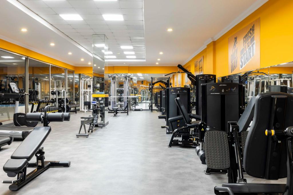 Wide view of the gym with benches, weights and resistance machines.
