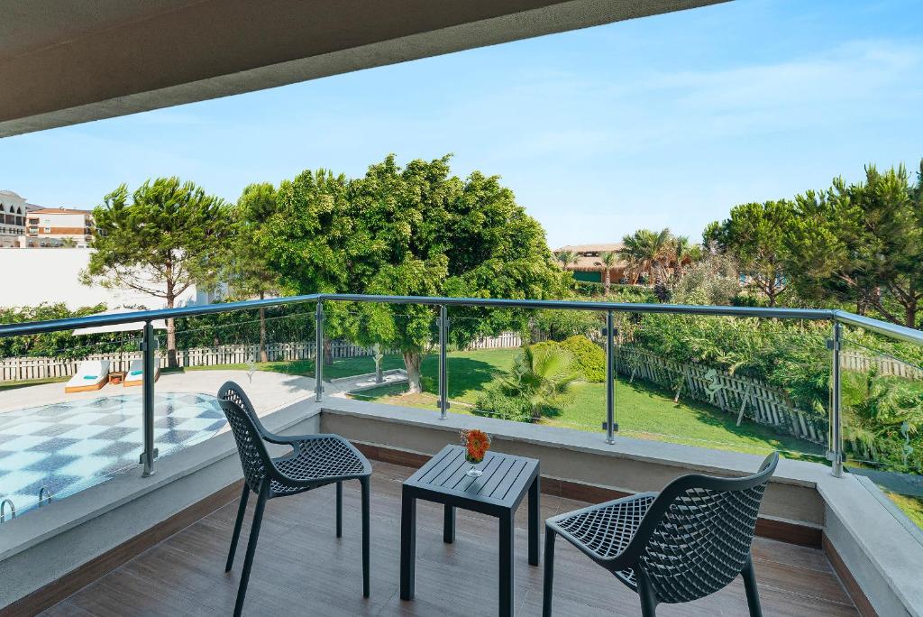 Balcony seating area overlooking garden and poolside surroundings.
