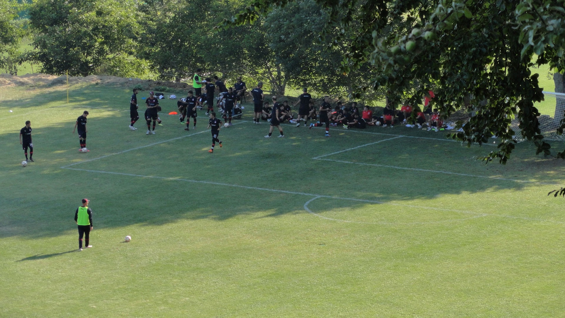 Football team gathered near the corner area during a training session.