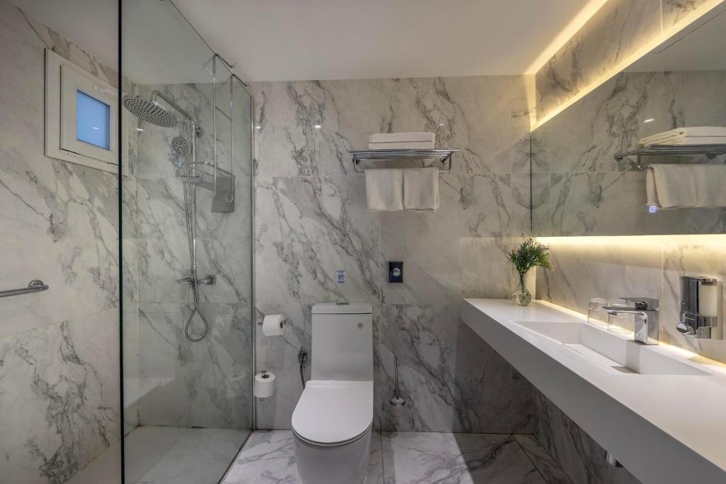 Marble bathroom with walk-in shower, toilet, and vanity