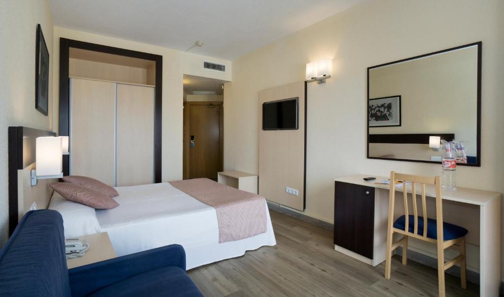Gästezimmer mit Doppelbett, Sofa, Schreibtisch, Kleiderschrank und Wand-TV.