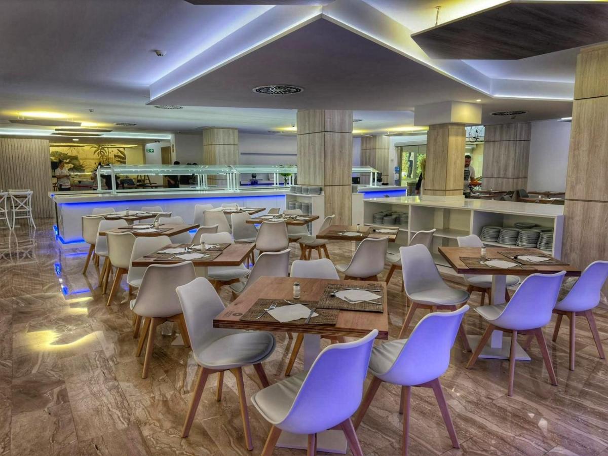 Buffet-Restaurant mit gedeckten Tischen und Selbstbedienungstheke.