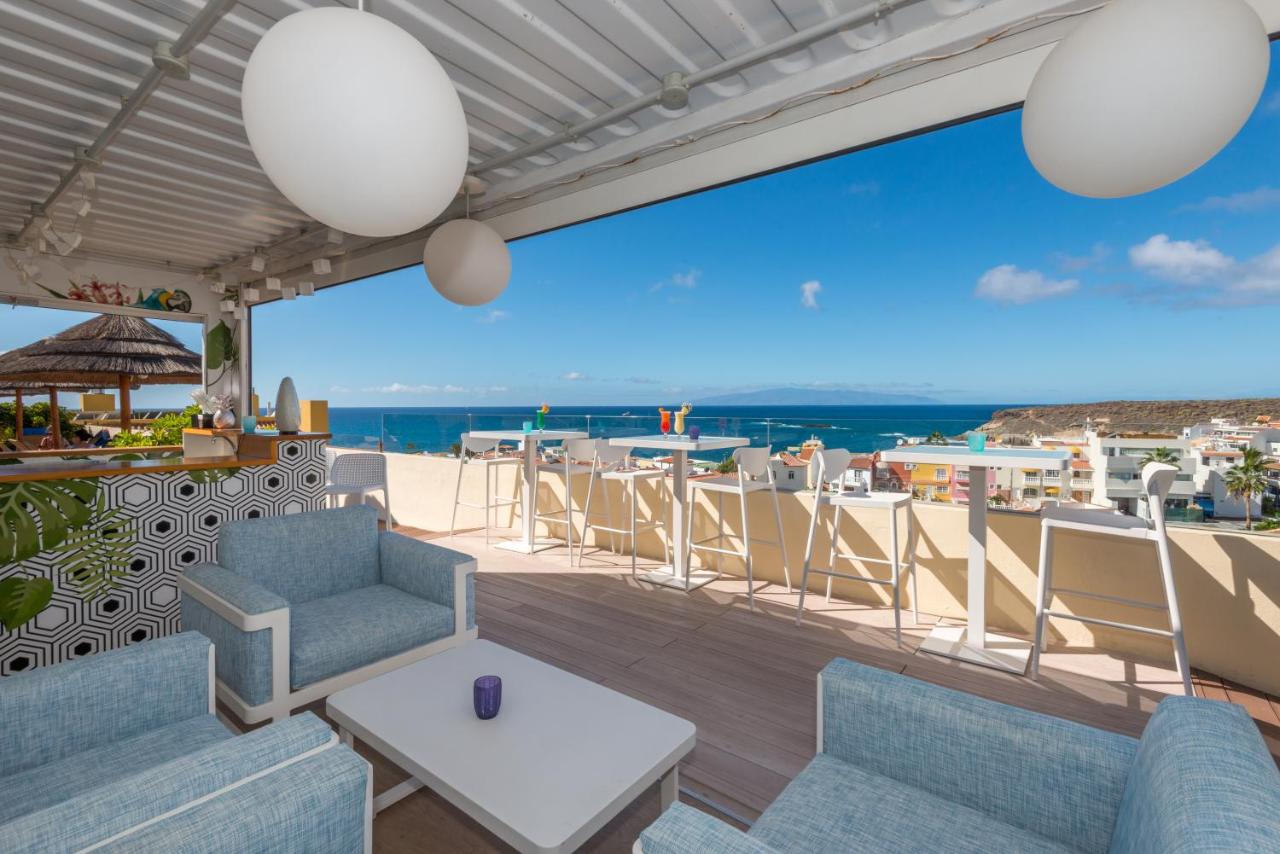 Rooftop lounge bar with seating and high tables overlooking the sea and town.