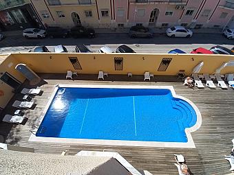 Outdoor pool and sun loungers in the hotel courtyard, viewed from above.