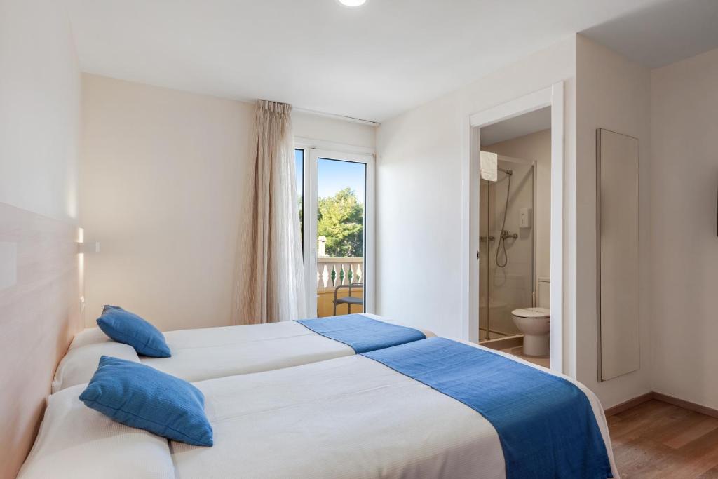 Chambre twin avec deux lits et espace salle de bains ouverte avec douche.