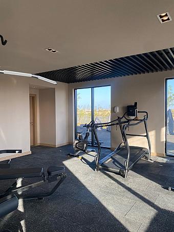 Training room with cardio machines, strength equipment, and bright windows