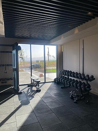 Fitness room with dumbbell rack, weight machines, and natural light