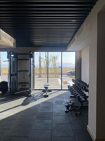 Gym space with free weights and equipment facing outdoor scenery