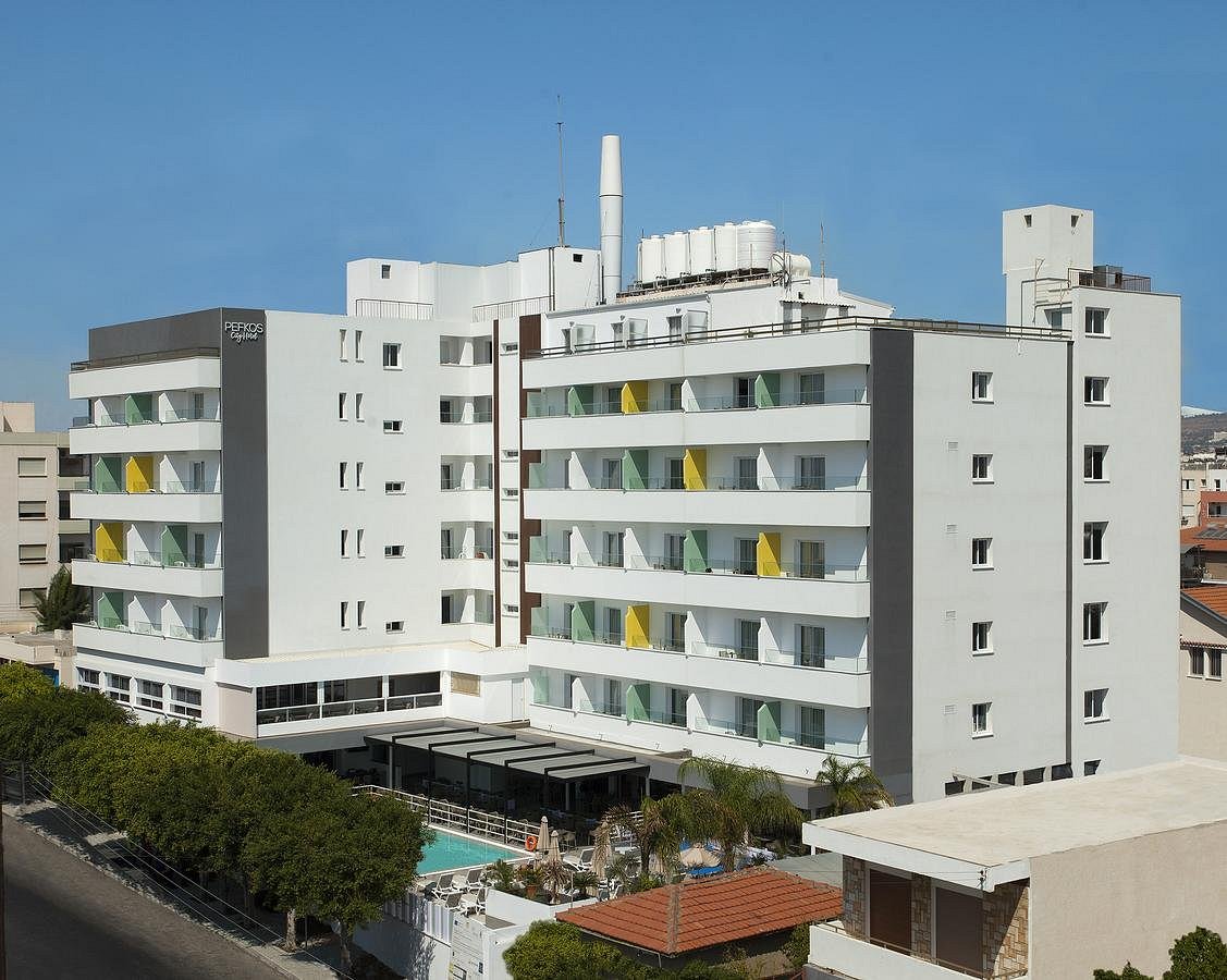 Exterior view of the hotel building with balconies, pool area and surrounding streets.