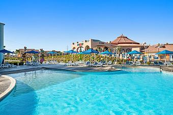 Outdoor pool with loungers and umbrellas at a family resort area