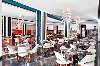 Modern restaurant with white chairs, brown accents, and decorative lighting