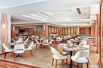 Indoor restaurant with white chairs and neatly set tables
