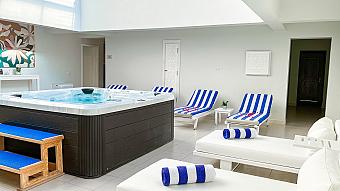 Spa relaxation area with jacuzzi, striped loungers, and white decor for post-workout recovery