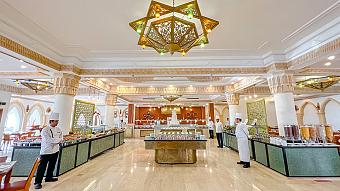 Elegant hotel buffet restaurant with chefs, decorative chandeliers, and extensive food stations