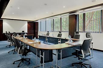 U-shaped meeting room with office chairs, projector screen and water bottles for a team training camp briefing