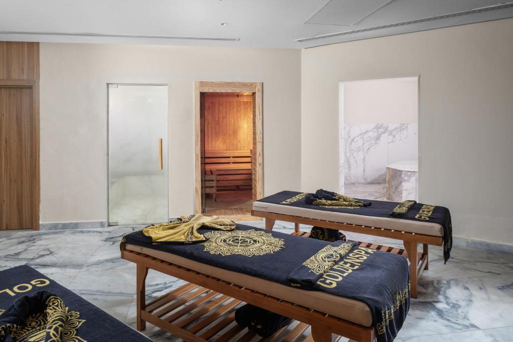 Spa-Behandlungsraum mit zwei Massageliegen, Handtüchern sowie Sauna-/Dampfbadbereich.