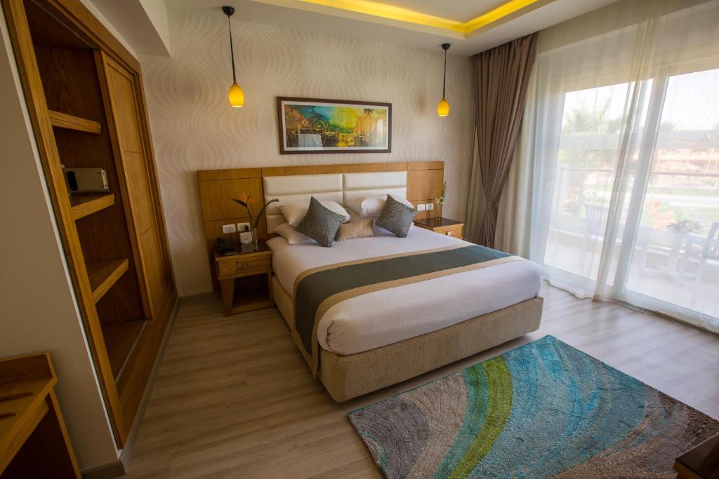 Helles Doppelzimmer mit großem Bett, Kleiderschrank und Schiebetüren zum Balkon/zur Terrasse.