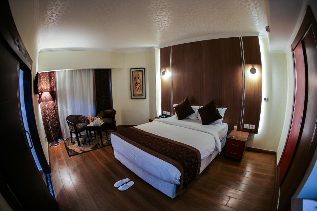 Double room with bed, small table and chairs, and floor-to-ceiling curtains.