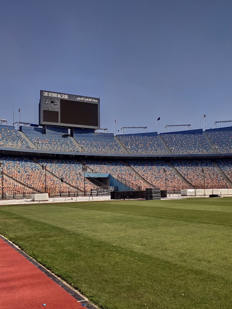 Blick vom Spielfeldrand auf die Sitzreihen und die Anzeigetafel des Cairo International Stadium.