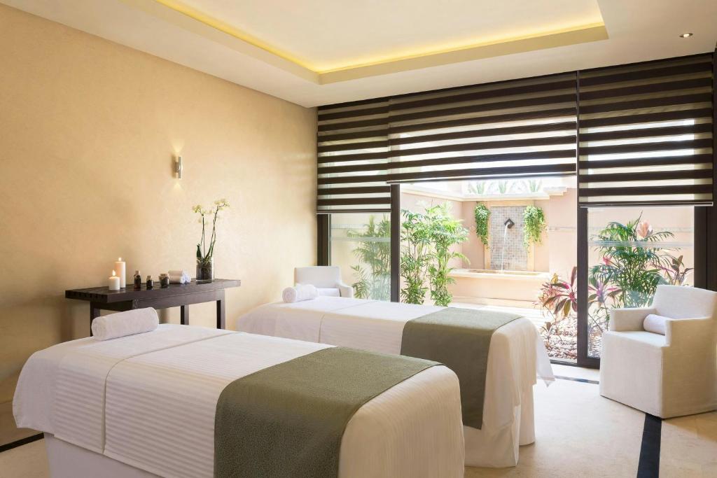 Spa-Behandlungsraum mit zwei Massageliegen, Kerzen und Patio-Blick für Recovery-Sessions.