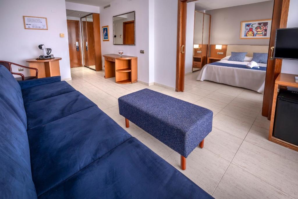 Suite mit Wohnbereich, Sofa und Couchtisch sowie separatem Schlafzimmer mit Doppelbett.