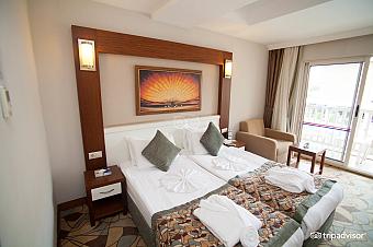 Twin room with balcony doors, bedside tables and seating corner.