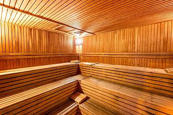 Wood-lined sauna with tiered benches for post-workout recovery.